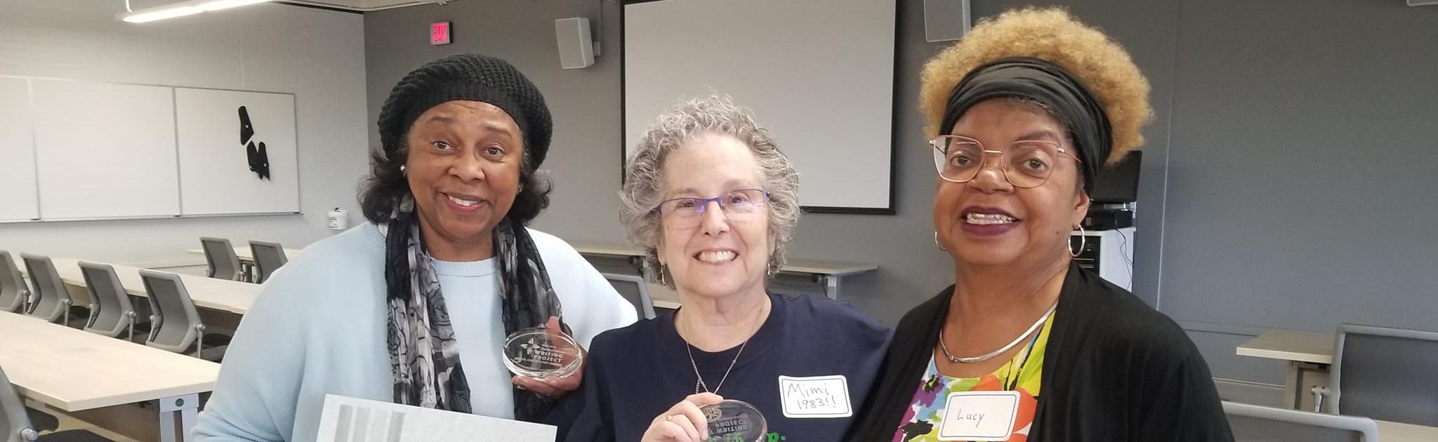 Three women holding awards