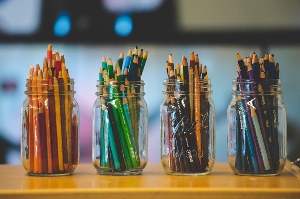 Jars filled with colored pencils.